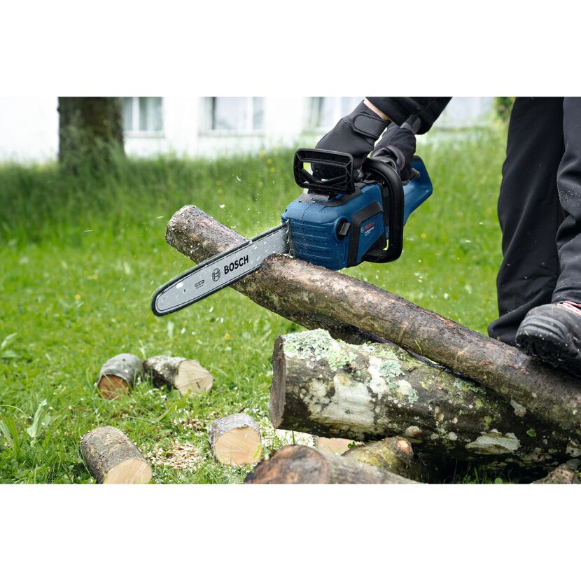 Person zerkleinert Holz mit Kettensäge