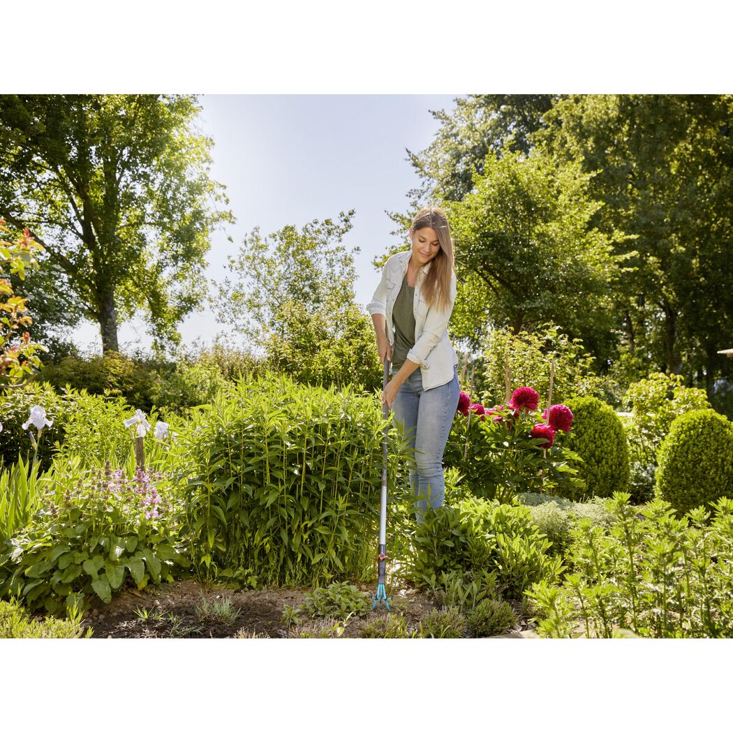 Person jätet mit Handjäter im Garten Unkraut