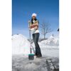 Person räumt Schnee mit Schneeschieber