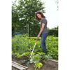 Person jätet mit Grubber im Garten.