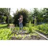 Person jätet mit Grubber im Garten