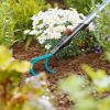 Hand hält einen Grubber Combisystem im Garten