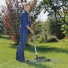 Person rechnet mit einem Rechen Gras im Garten zusammen.