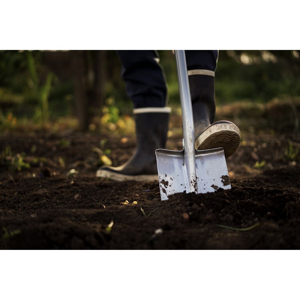 Person gräbt mit Spaten im Garten
