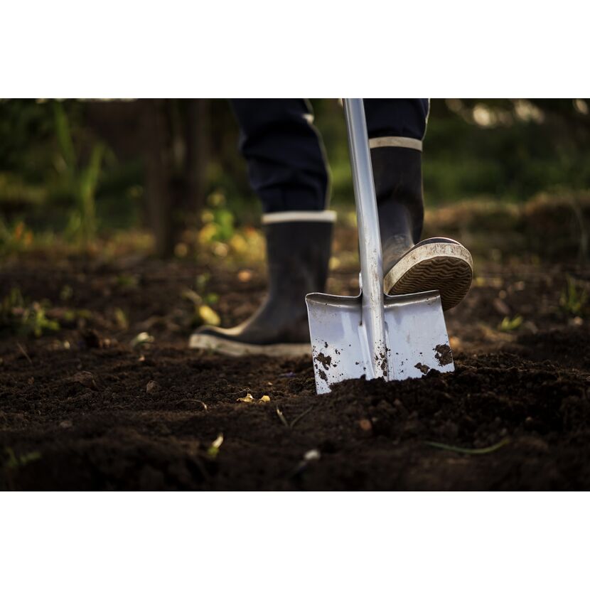 Person gräbt mit Spaten im Garten