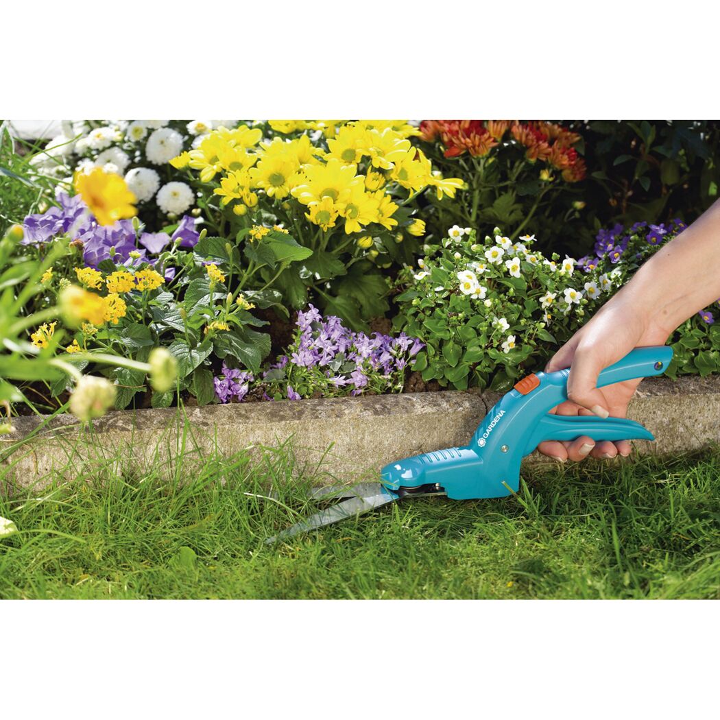 Person schneidet Gras mit GARDENA Grasschere Classic