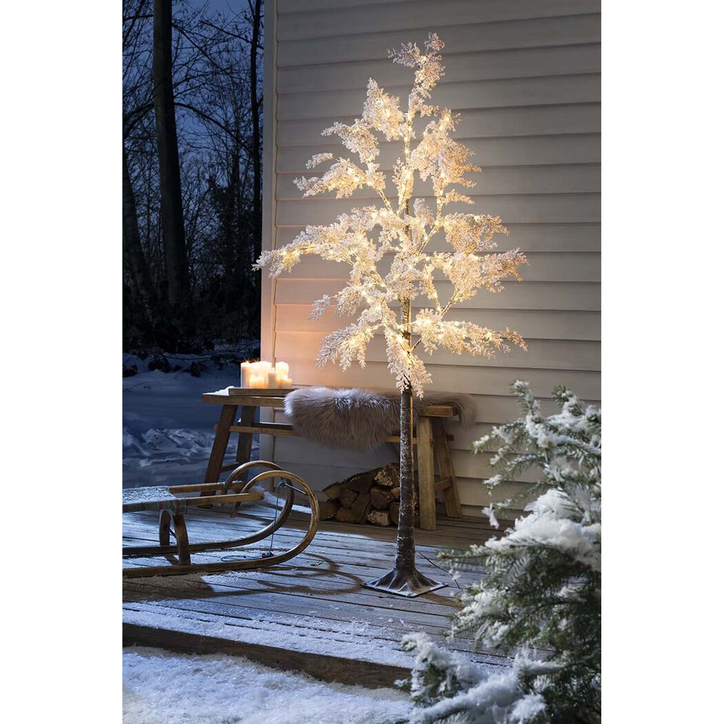 Beleuchteter künstlicher Baum mit Schnee-Effekt im Freien