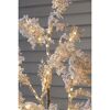 Künstlicher Baum mit Schnee und Lichtern