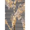 Beleuchteter künstlicher Baum mit Schnee-Effekt