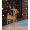 Goldenes Rentier mit Lichtern im Schnee