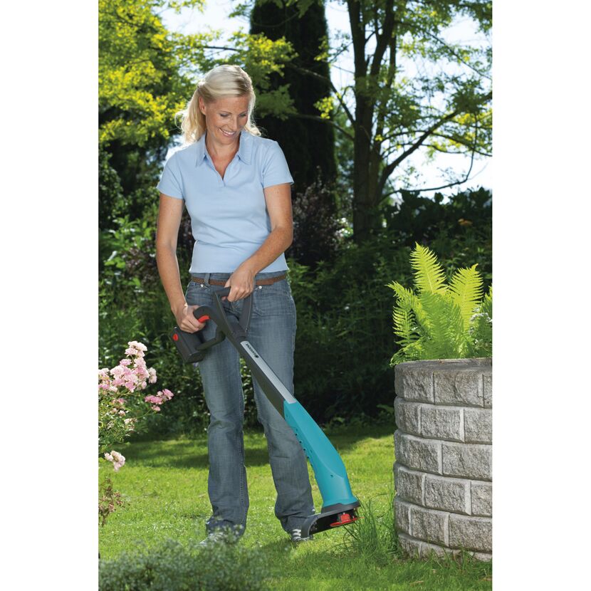 Person verwendet Akku-Rasentrimmer SmallCut 300 im Garten.
