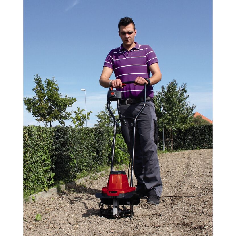 Person bearbeitet Boden mit elektrischer Bodenhacke.