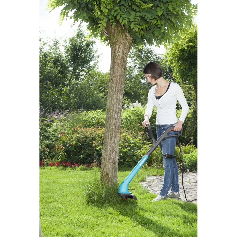Person trimmt Gras mit GARDENA SmallCut 300/23