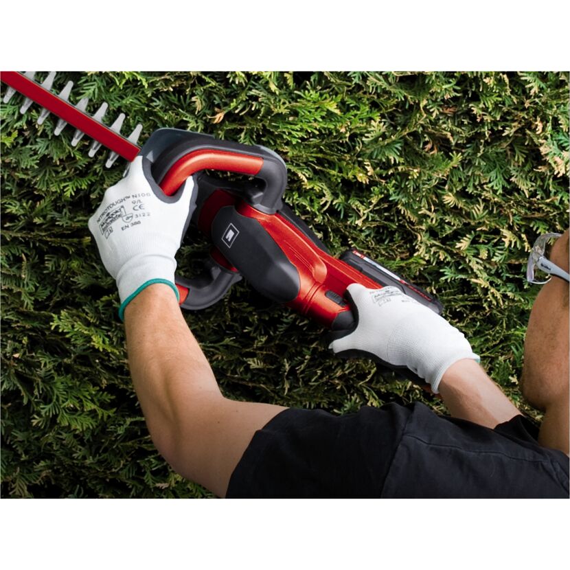 Person schneidet Hecke mit Akku-Heckenschere