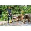 Person reinigt Holzterrasse mit Kärcher MultiBrush Speedcontrol.