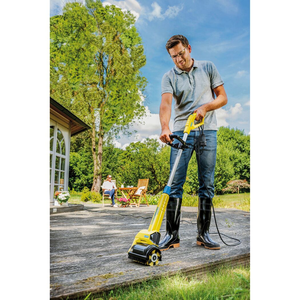 Person reinigt Holzterrasse mit dem Kärcher Powerbrush.