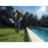 Person trimmt Rasen mit Motorsense am Pool.