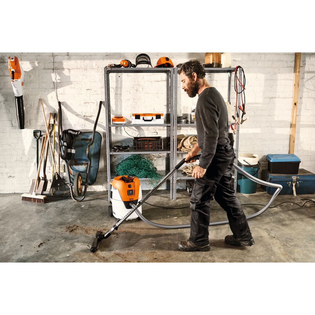 Person saugt Schmutz mit Stihl SE 62 Nass- und Trockensauger