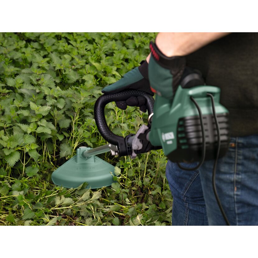Person verwendet Rasentrimmer im Garten