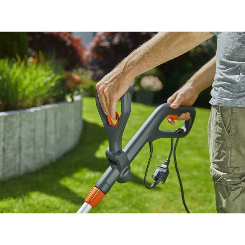 Person hält einen EasyCut 450/25 Trimmer