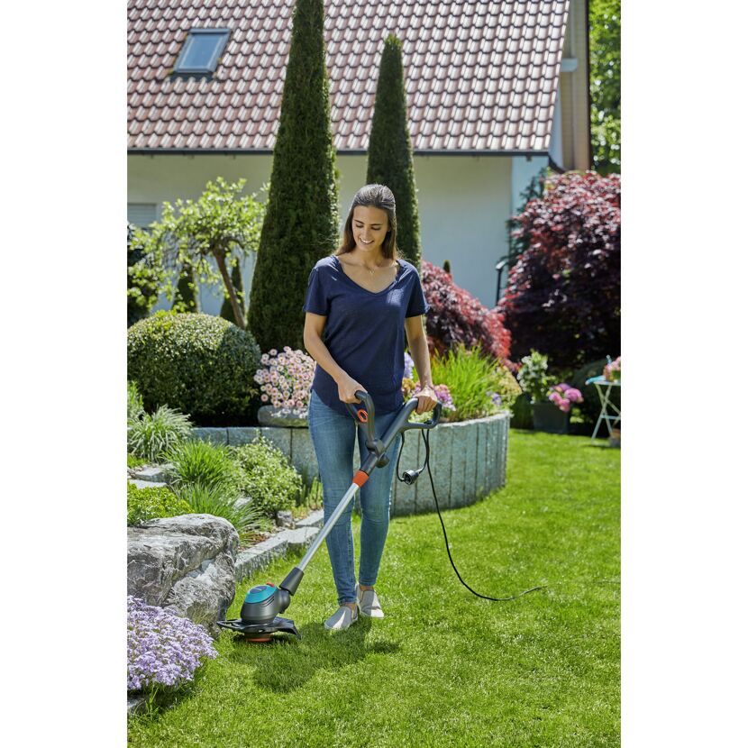Person mäht Rasen mit Elektro-Trimmer EasyCut 450/25