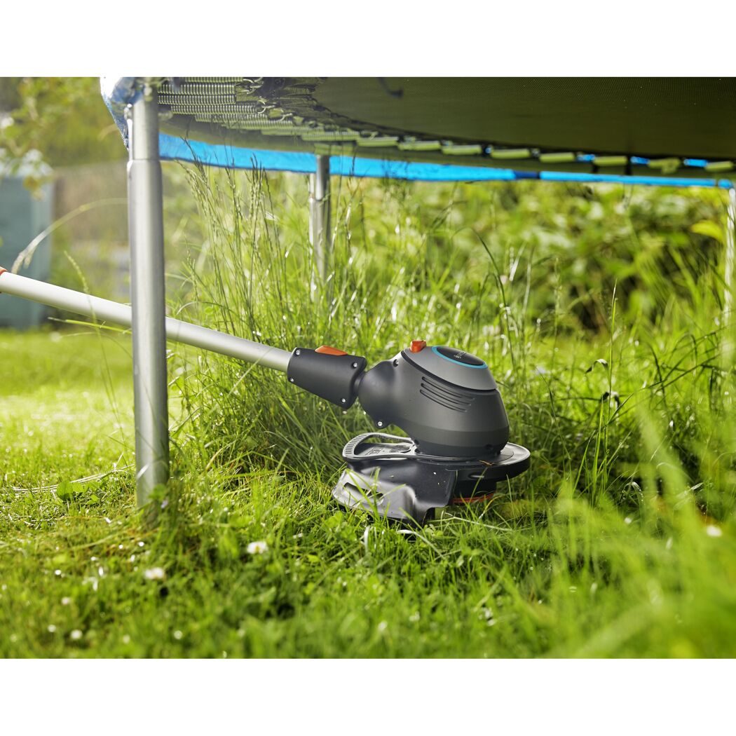 Elektro-Rasentrimmer unter einem Trampolin