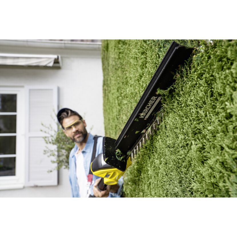Person schneidet Hecke mit Akku-Heckenschere