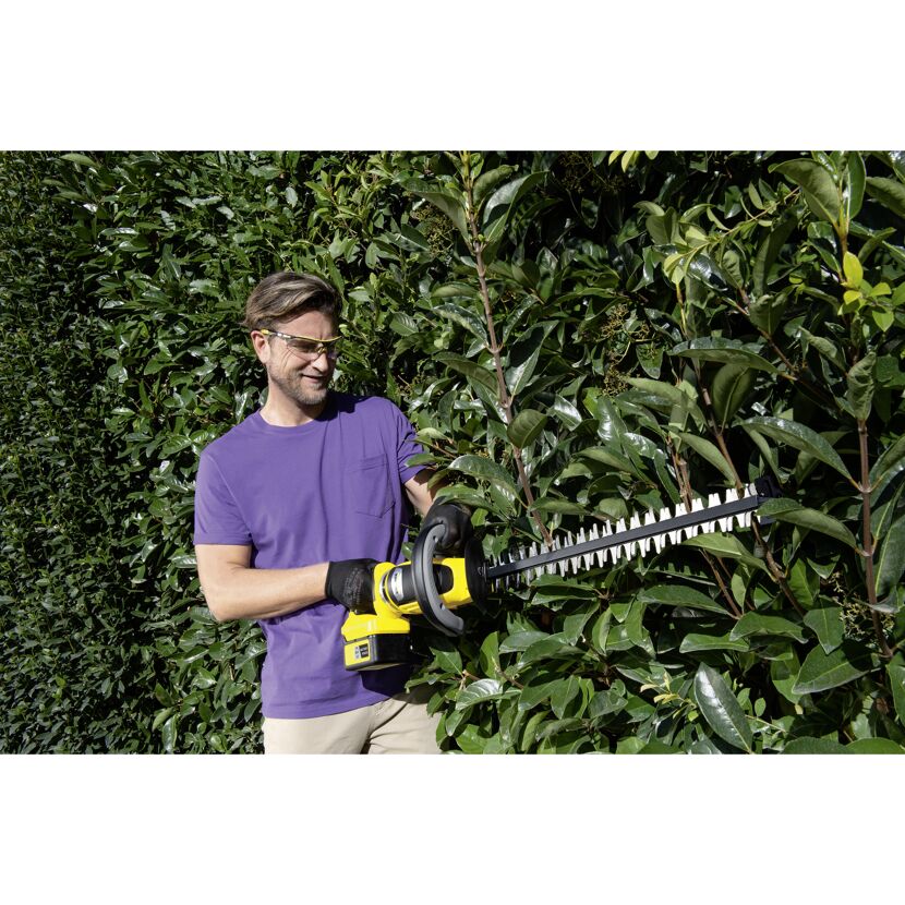 Person schneidet Hecke mit Akku-Heckenschere