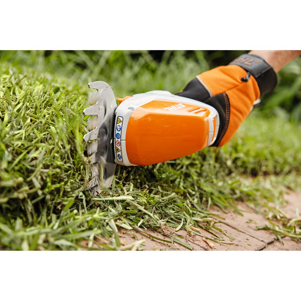 Person schneidet Gras mit Akku-Strauchschere HSA 26 von STIHL