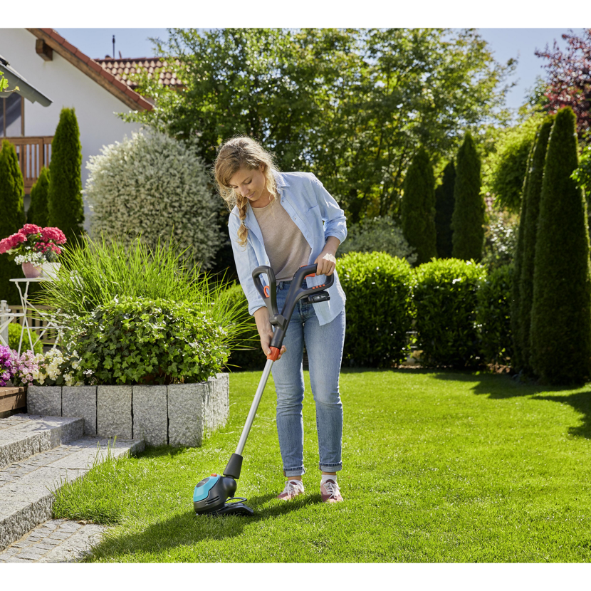 Person verwendet Akkutrimmer EasyCut Li-18/23 im Garten