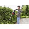 Person schneidet eine Hecke mit einer Heckenschere.