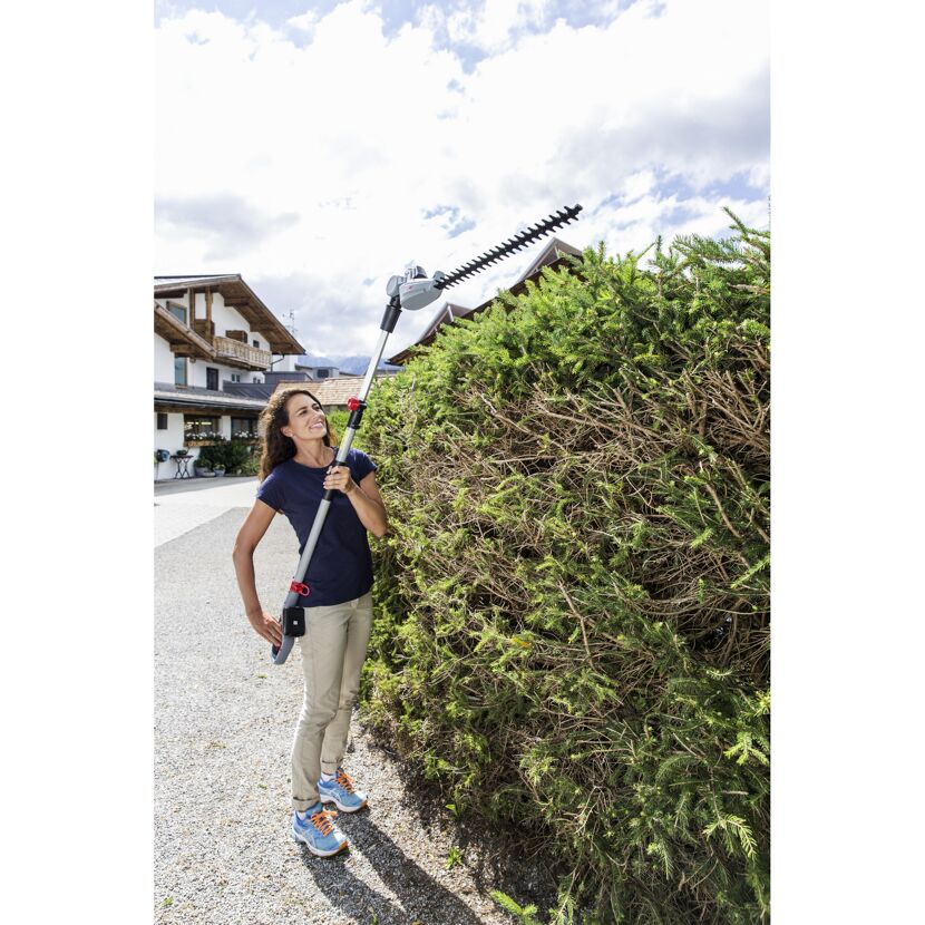 Person schneidet Hecke mit Heckenschere