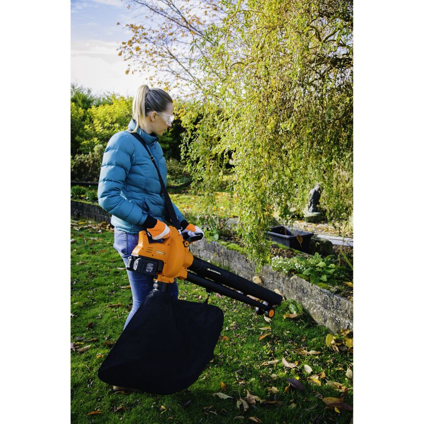 Person verwendet Laubbläser im Garten
