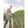 Person schneidet Hecke mit Heckenschere