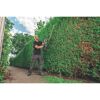 Person schneidet Hecke mit Heckenschere