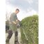 Person schneidet Hecke mit Heckenschere