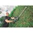 Person schneidet Hecke mit Heckenschere