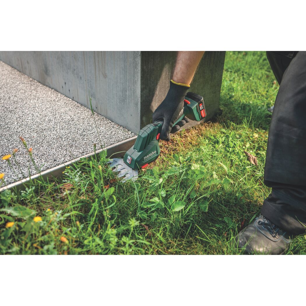 Person schneidet Gras mit Akku-Grasschere