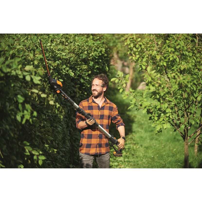 Person schneidet Hecke mit Akku-Teleskop-Heckenschere