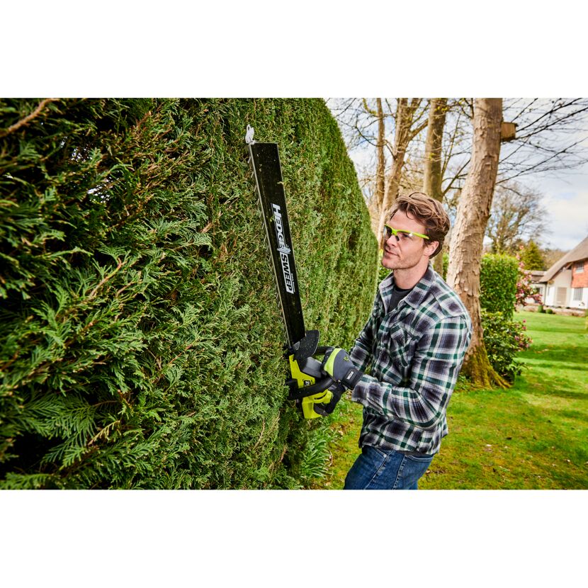 Person schneidet Hecke mit Akku-Heckenschere