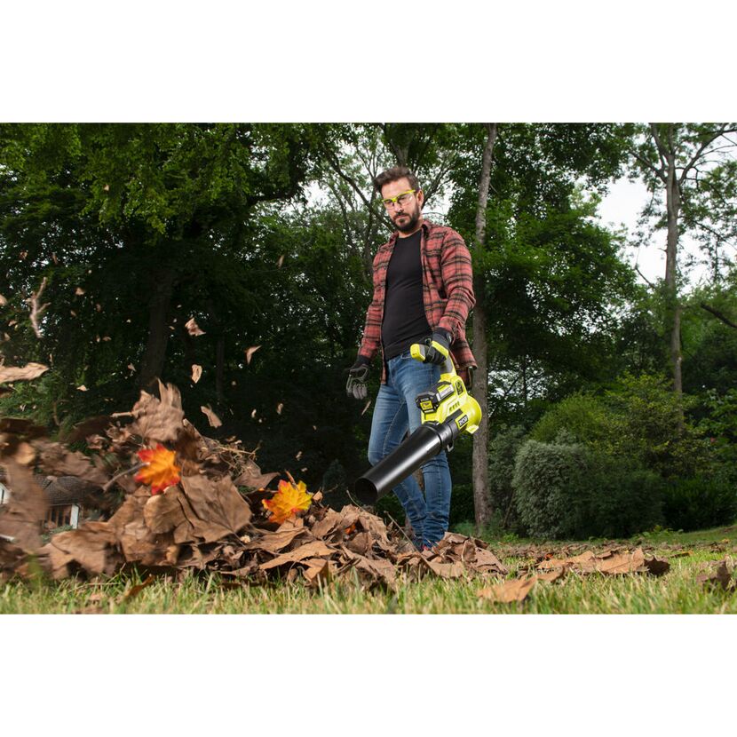 Person verwendet Laubbläser im Garten