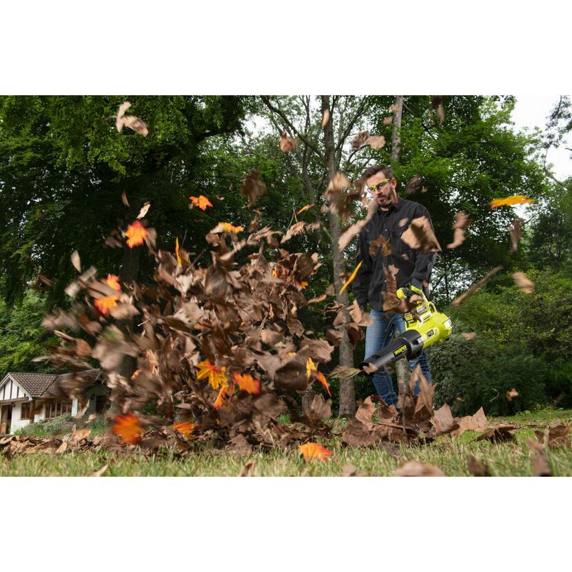 Person verwendet Laubbläser im Garten.