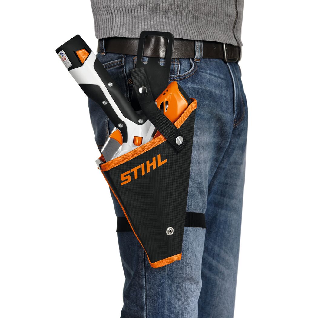 Person trägt eine STIHL Akku-Heckenschere GTA 26 im Holster.