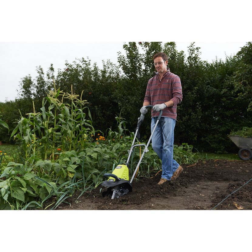 Person verwendet einen Ryobi Kultivator im Garten.