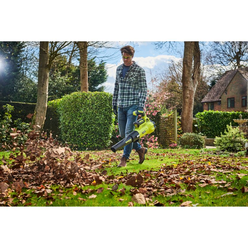 Person verwendet Laubbläser im Garten