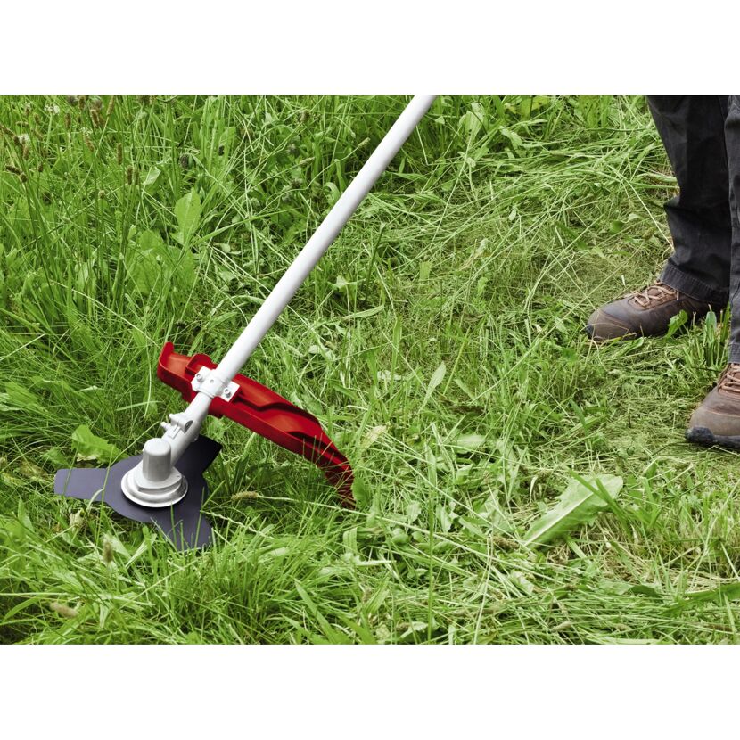 Person mäht Gras mit einem Freischneider.