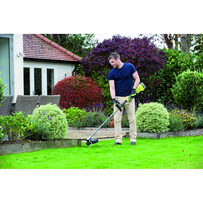 Person verwendet Akku-Rasentrimmer im Garten.