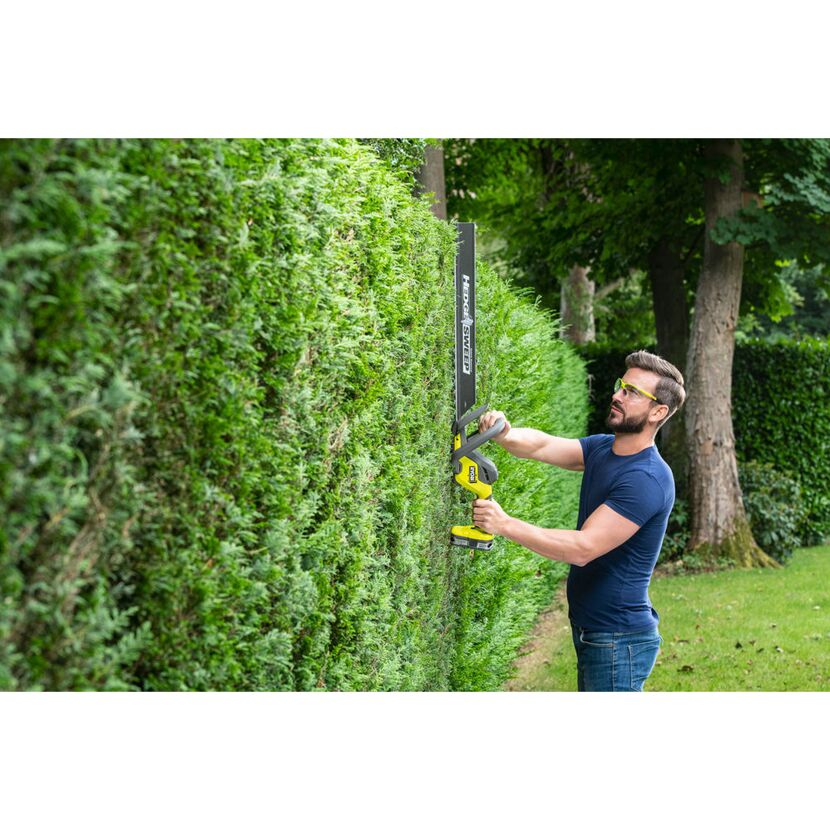 Person schneidet Hecke mit Akku-Heckenschere
