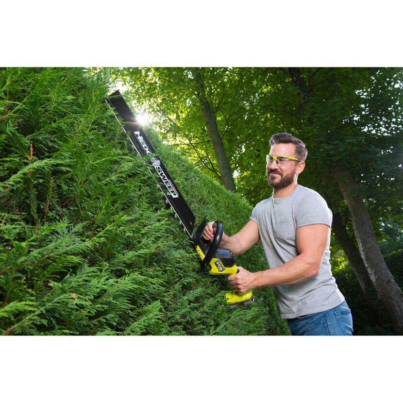Person schneidet Hecke mit Akku-Heckenschere