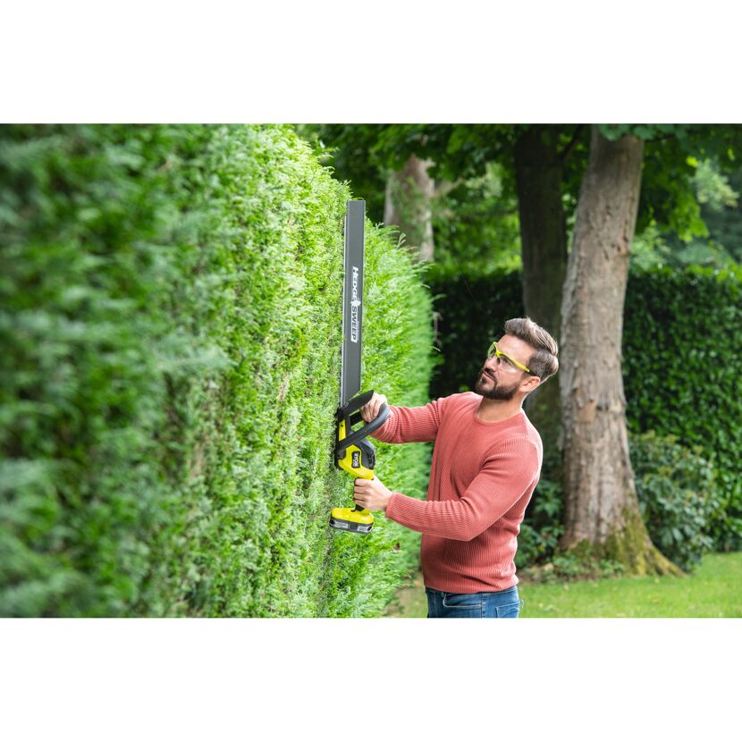 Person schneidet Hecke mit Akku-Heckenschere